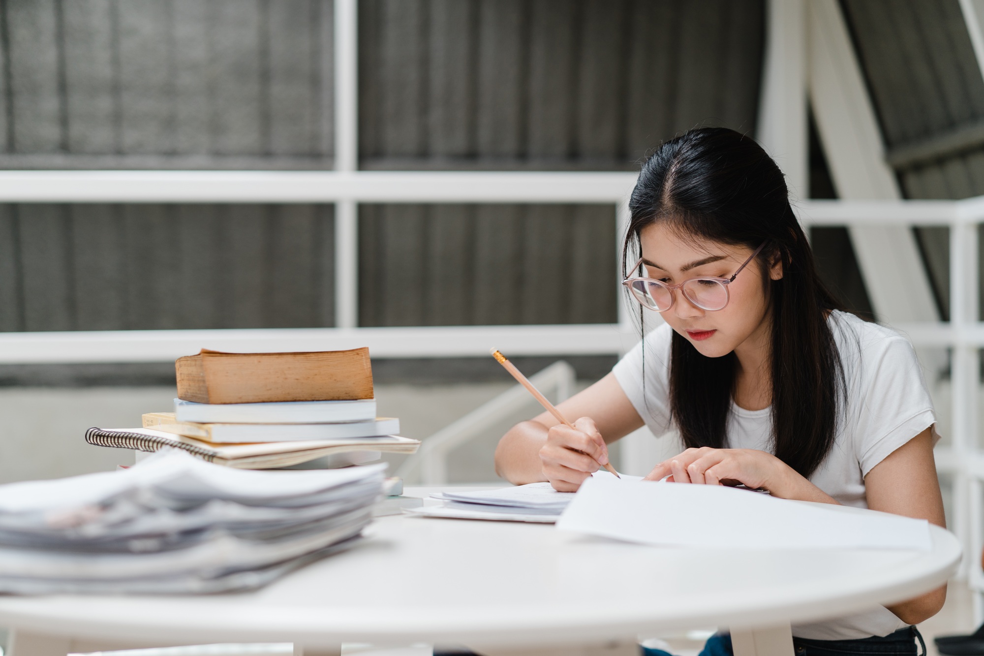 Asian student women reading books in library at university.